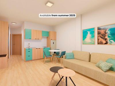 Soggiorno moderno con divano, tavolo da pranzo e armadi colorati in toni di legno chiaro.