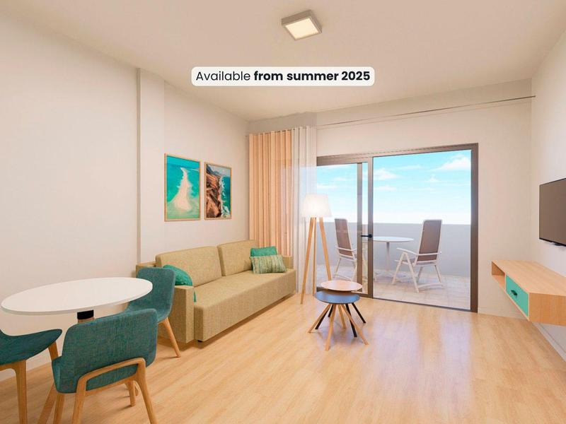 Soggiorno luminoso con zona pranzo, divano e accesso alla terrazza con vista mare.