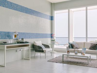 Modern, bright balcony seating area with white furniture and blue striped walls.