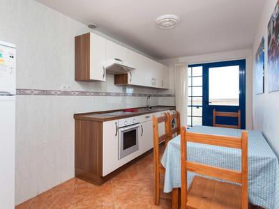 Small kitchen with table, chairs, and oven in a vacation apartment.