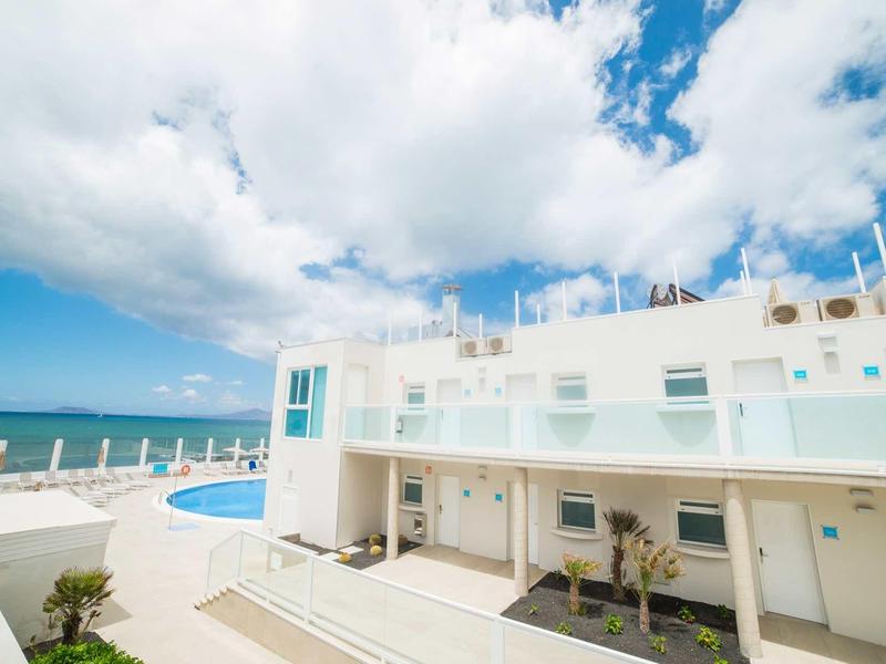Edificio moderno di hotel con piscina e vista sul mare blu sotto un cielo nuvoloso