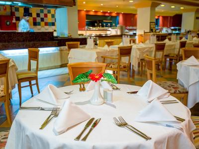 Ristorante elegante dell'hotel con tovaglie bianche e mobili in legno.