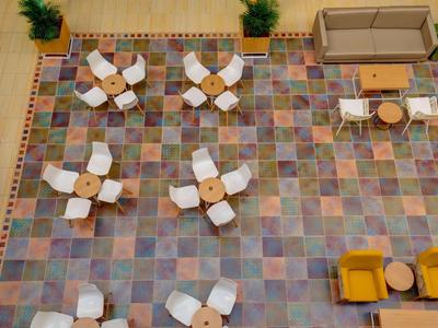 Vista aerea di un'area lounge multifunzionale con sedie, tavoli e divani.