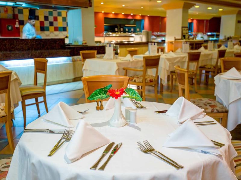 Ristorante elegante dell'hotel con tovaglie bianche e mobili in legno.