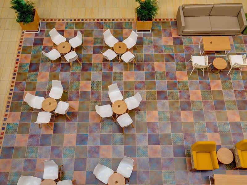 Vista aerea di un'area lounge multifunzionale con sedie, tavoli e divani.