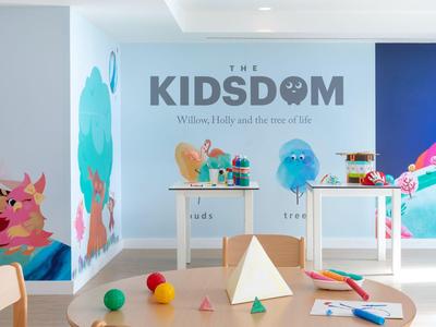 Bright playroom with colorful wall art and toys for children in a hotel.