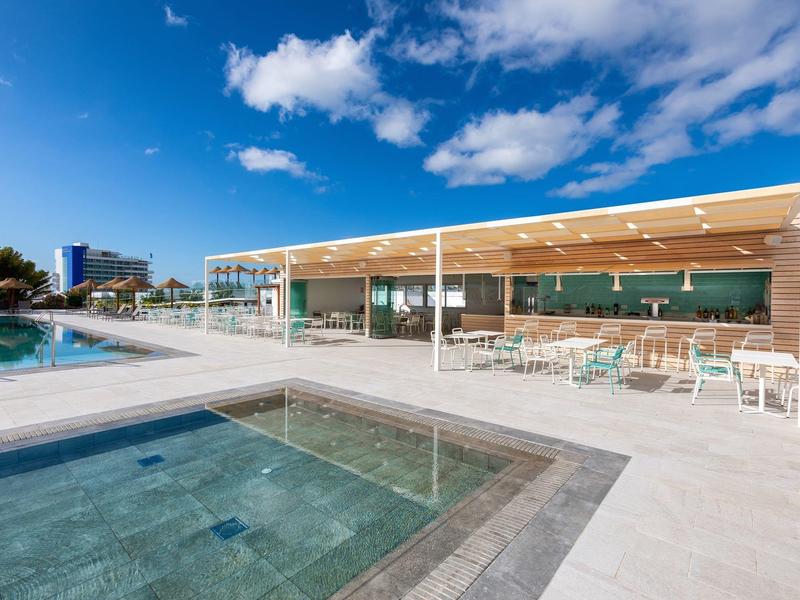 Terrazza dell'hotel con piscina, vasca idromassaggio e cielo blu.