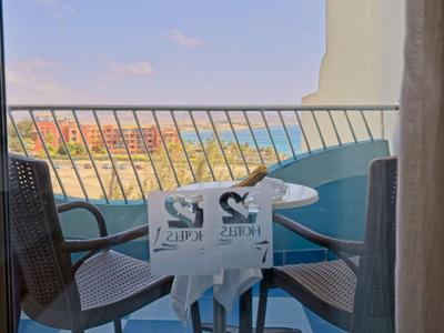 Balcone con due sedie e piccolo tavolo con vista mare in una giornata di sole