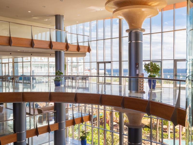 Moderna hall dell'hotel con grandi vetrate e architettura elegante in legno e metallo