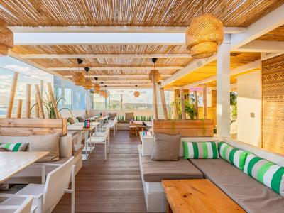 Helles Lounge-Bereich eines Hotels mit Holzmöbeln und natürlicher Dekoration.