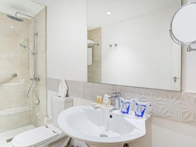 Bagno moderno con doccia, lavandino e specchio illuminato.