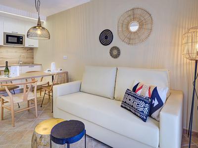 Soggiorno arredato in stile moderno con divano bianco e zona pranzo in toni caldi.