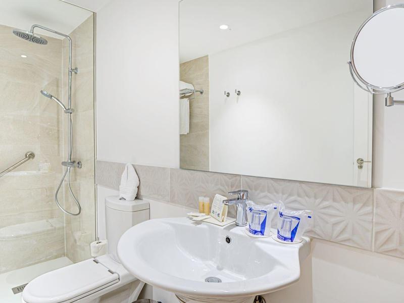 Bagno moderno con doccia, lavandino e specchio illuminato.