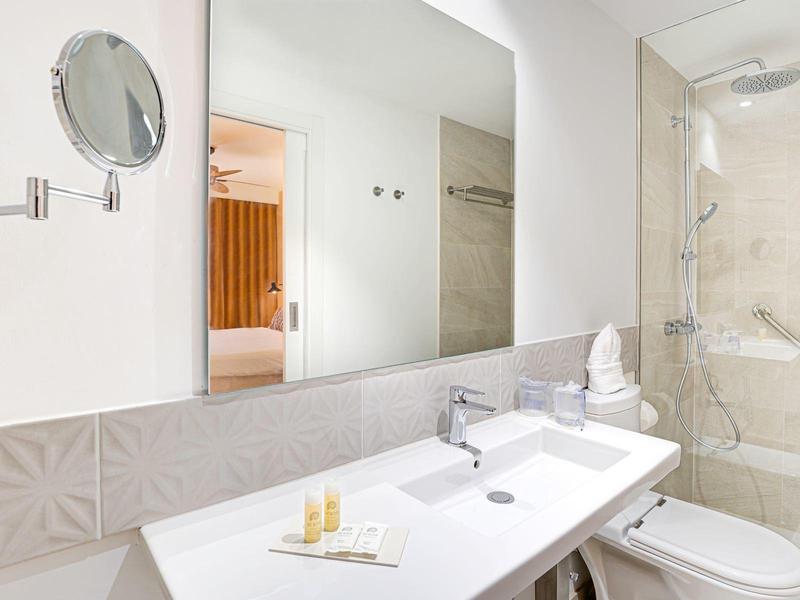 Bagno luminoso con doppio lavabo, specchio, specchio cosmetico ingrandente e doccia a filo pavimento.