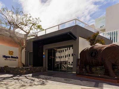 Modernes Hotelgebäude mit großer Bison-Skulptur vor Eingang und Baum ohne Blätter.