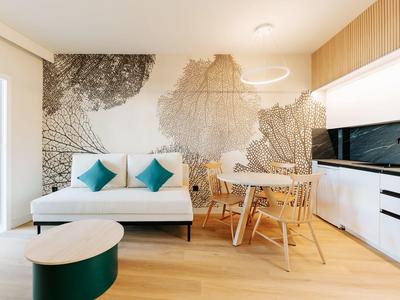 Modernes Wohnzimmer mit weißem Sofa, Holzfußboden, runder Lampe und Wanddekoration in Schwarz-Weiß.