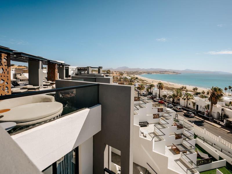 Vista dal balcone su edifici moderni e linea costiera sotto un cielo limpido.