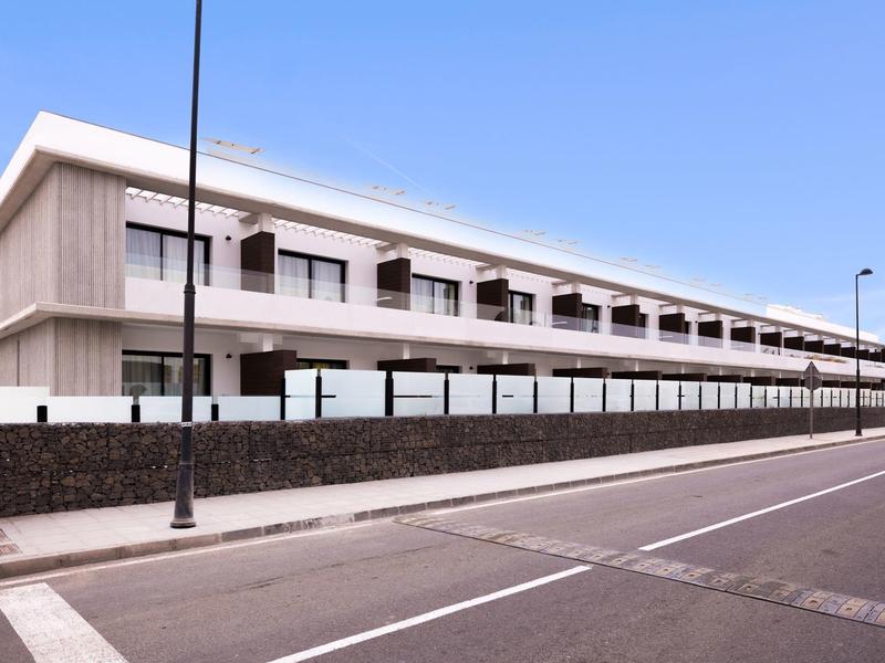 Edificio di hotel moderno a due piani con balconi e lampioni in primo piano.