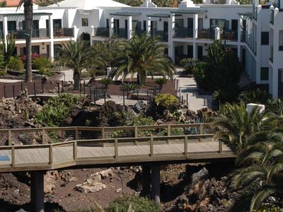 Edificio dell'hotel bianco con palme e montagna sullo sfondo vicino al mare