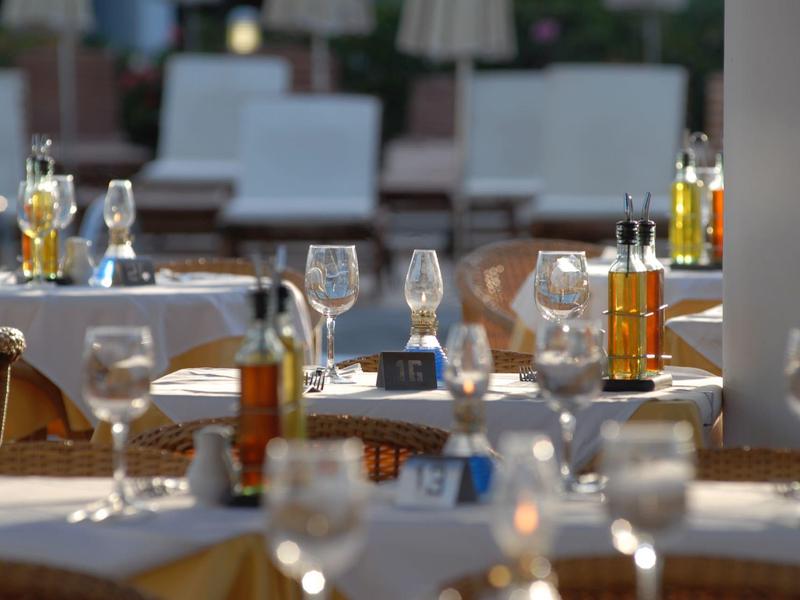 Ristorante elegante con tavoli apparecchiati e bicchieri in un'atmosfera rilassata.