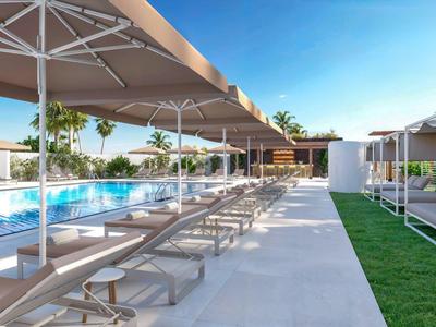 Moderne buitenzwembadruimte met ligstoelen, parasols en groene planten onder een blauwe lucht.