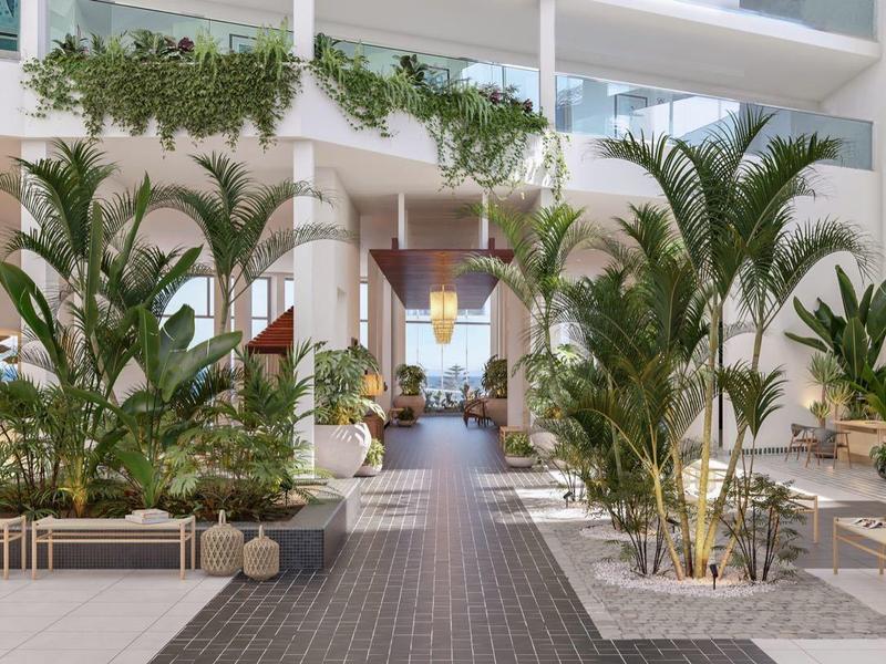 Moderne hotelbinnenplaats met zitgedeeltes en groene planten bij natuurlijk licht.