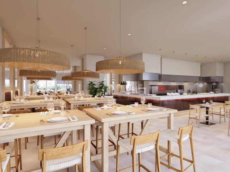 Modern, licht restaurant met houten en natuurlijke inrichting, grote lampen en open keuken.