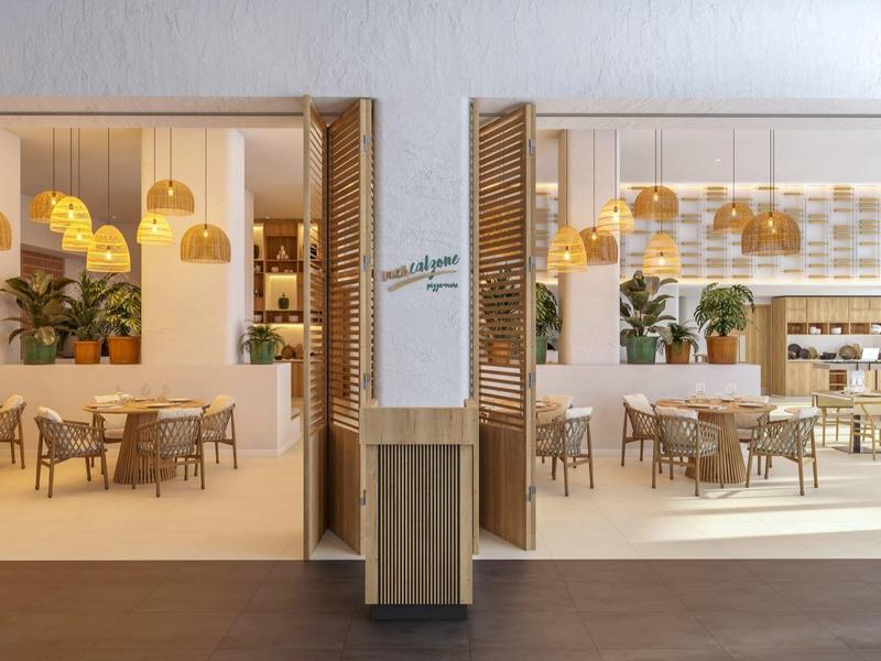 Modern, helder restaurant met houtdecoratie, planten en hanglampen.