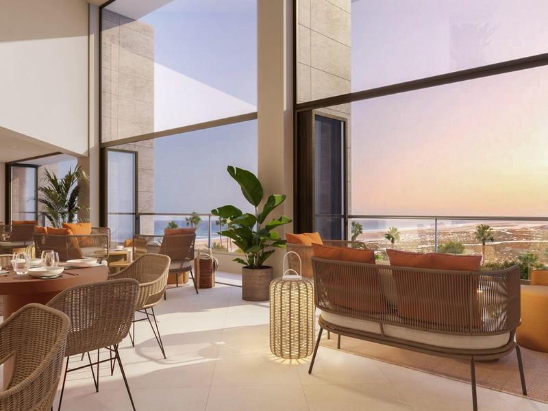 Moderne lichte restaurantruimte met panoramische ramen en uitzicht op de zonsondergang.