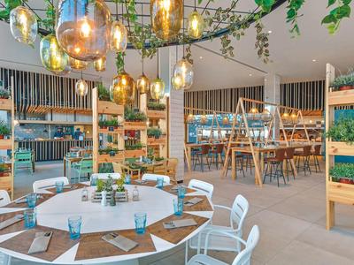 Área moderna al aire libre de un hotel con iluminación elegante y asientos relajados.