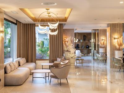 Elegante area lobby dell'hotel con poltrone moderne, divani e grandi finestre.