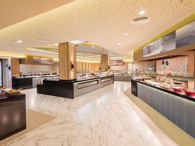 Moderner Hotel-Speisesaal mit Marmorfußboden und umfangreichem Buffetbereich.