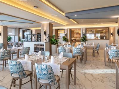 Elegantes Restaurant mit modernen Möbeln und gedeckten Tischen in hellem Ambiente.