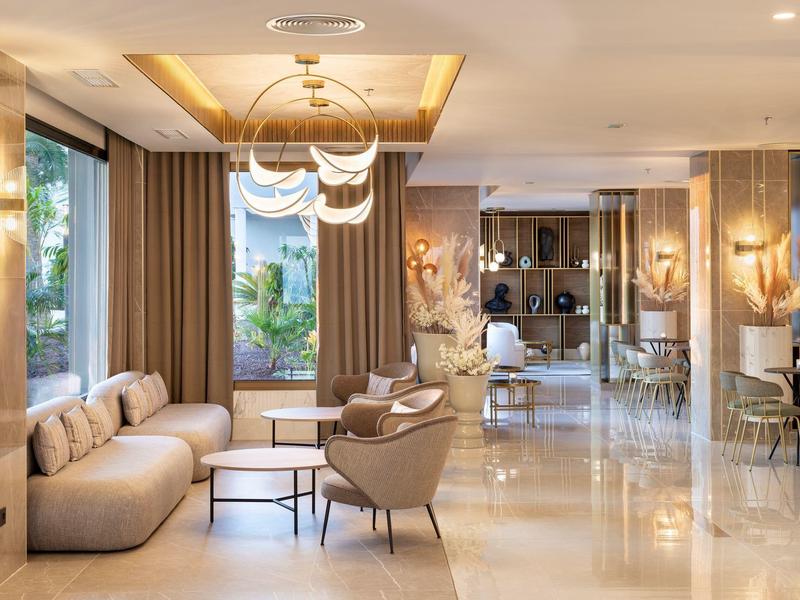 Elegante area lobby dell'hotel con poltrone moderne, divani e grandi finestre.