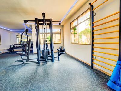 Moderner Fitnessraum mit Trainingsgeräten und Fenster mit Tageslicht