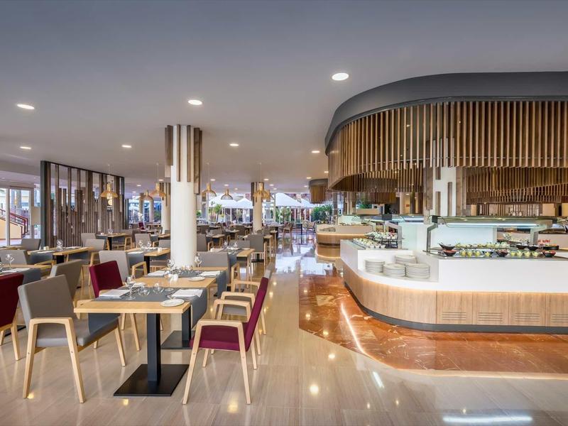 Modern hotel restaurant with wooden accents, elegant seating, and bright lighting.