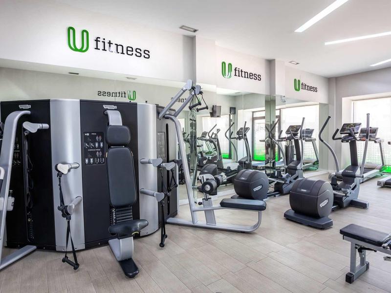 Modern hotel fitness center with various exercise machines and cardio equipment.