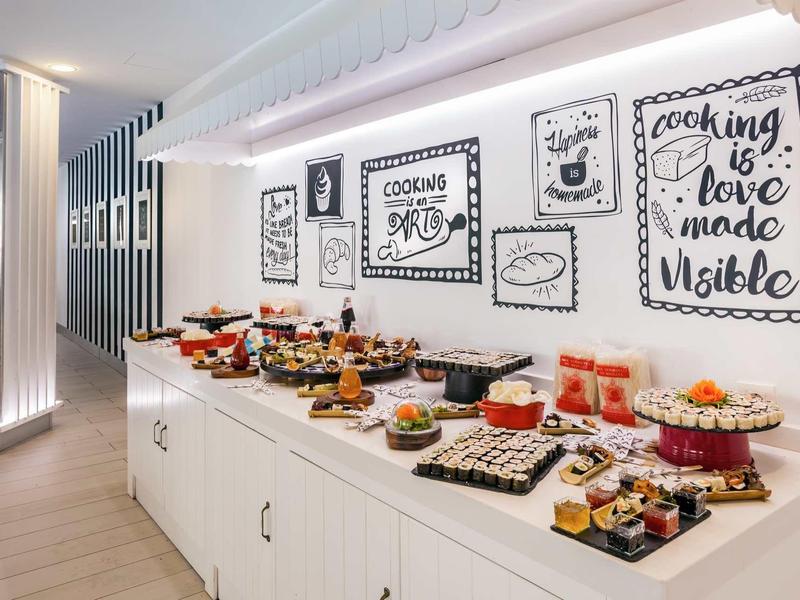 Bright buffet area with various desserts and framed cooking quotes on the wall.