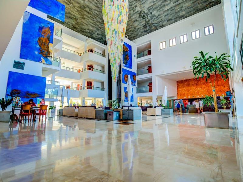 Ampia hall dell'hotel con design moderno, grande scultura e aree salotto confortevoli.