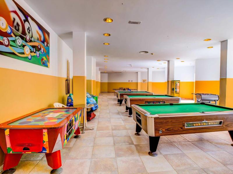 Sala giochi con tavoli da biliardo e tavolo da air hockey in un hotel.