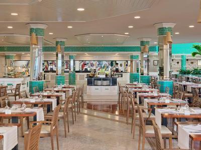 Large, elegant dining room with wooden tables and white tablecloths in a hotel.