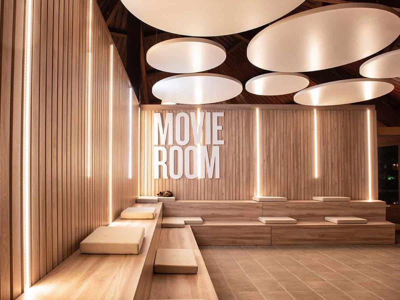 Moderní hotelový kinosál s dřevěným obložením a atmosférickým osvětlením