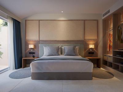 Modern hotel room with large bed, bedside lamps, round rugs, and a wooden wardrobe.