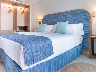 Modern eingerichtetes Hotelzimmer mit großem Bett und blauem Dekor.