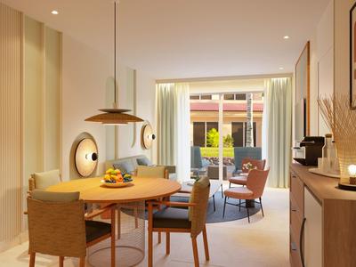 Bright hotel room with round table, chairs, and a view of a patio through glass doors.