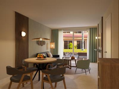 Modern hotel room with dining table, chairs, and large window showing an outdoor seating area.