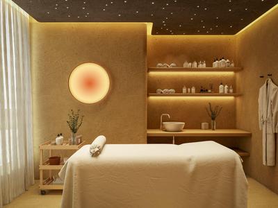 Warm, cozy spa room with massage table, soft lighting, and minimalist wooden shelves.