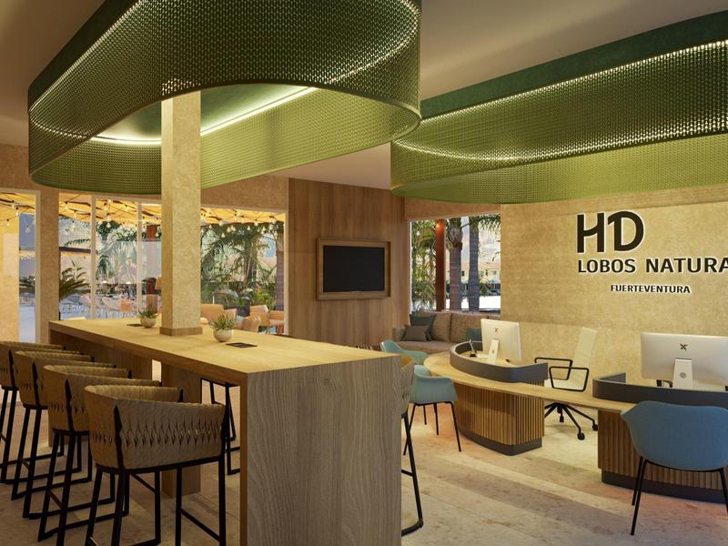 Modern hotel lounge with wooden tables, bar stools, and large windows overlooking trees.