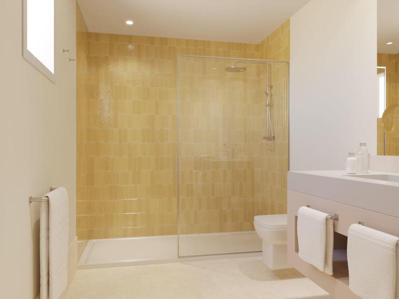 Modern bathroom with beige tiled walk-in shower and white fixtures in a hotel room.