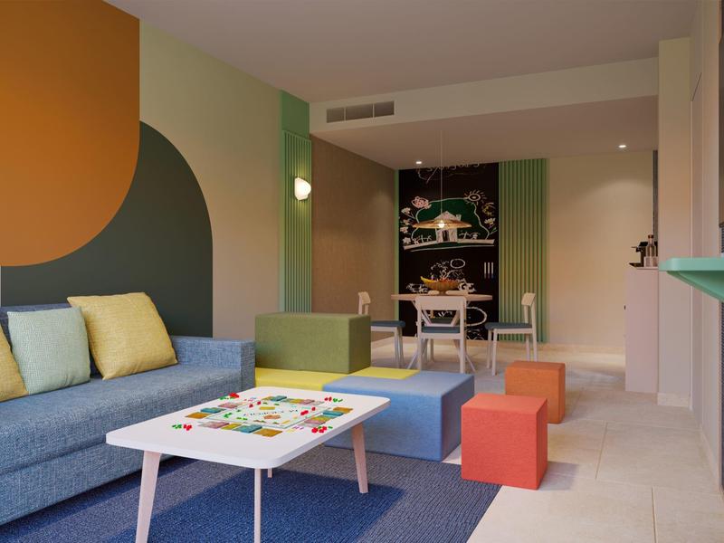 Modern living room with blue sofa, colorful cushions, and a game table with stools.